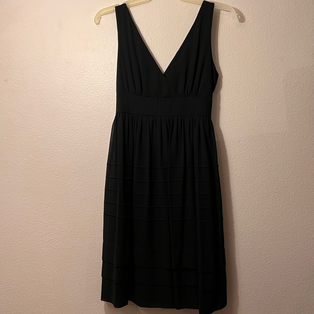 Black knee dress with deep chest slit and waist wrap.